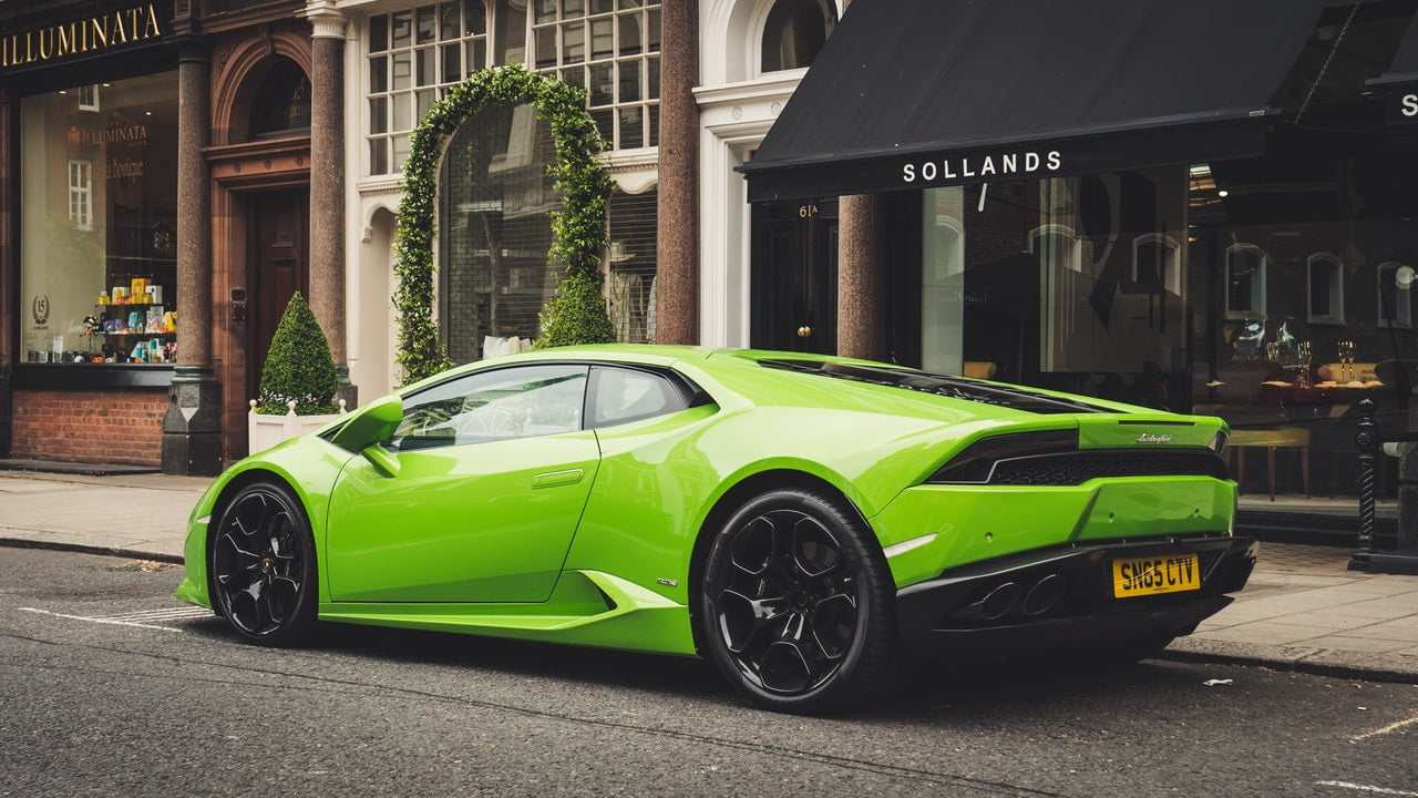 Green Lamborghini Parked In Front Of A Caffe