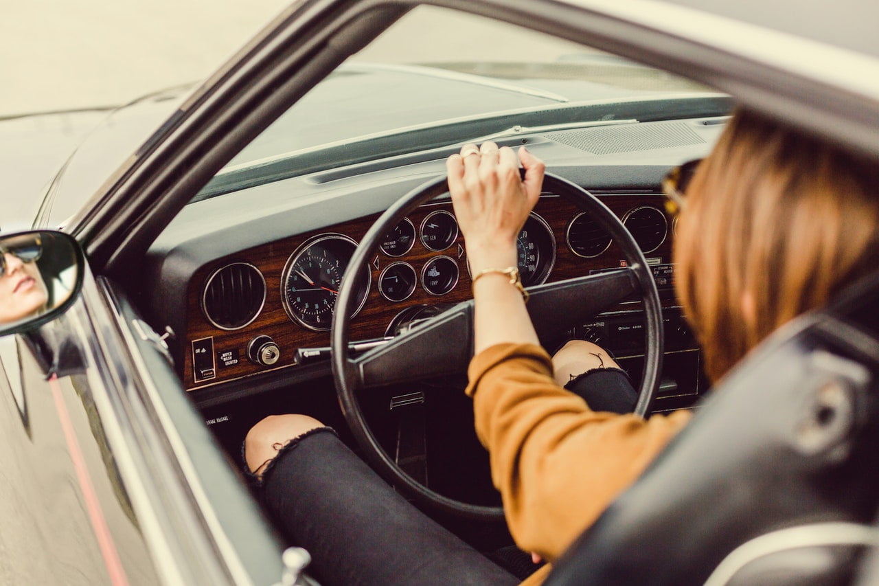 Woman Steering a Wheel In A Black Vehicle